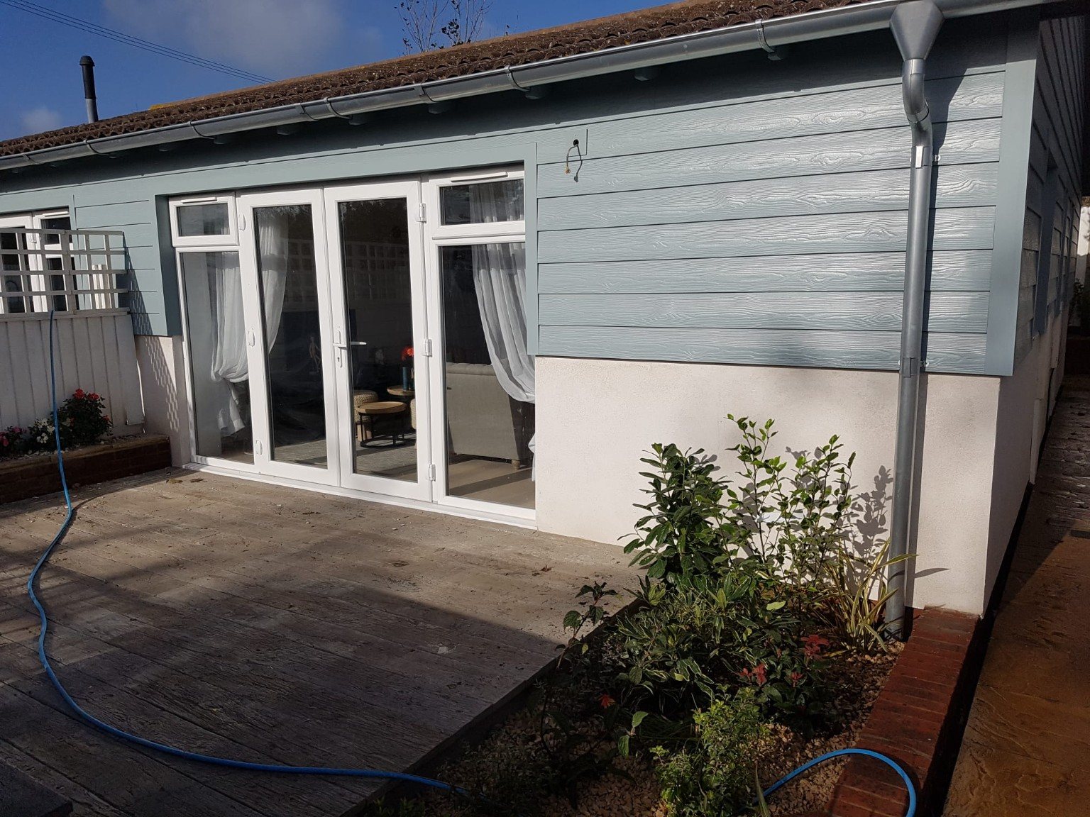 Finished blue cladding exterior with white patio doors
