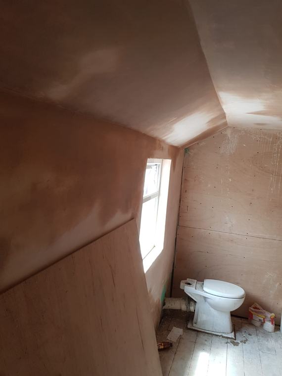 Small bathroom area with fresh plaster on sloped ceiling
