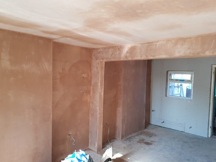 Large interior space with fresh plaster and boarded wall