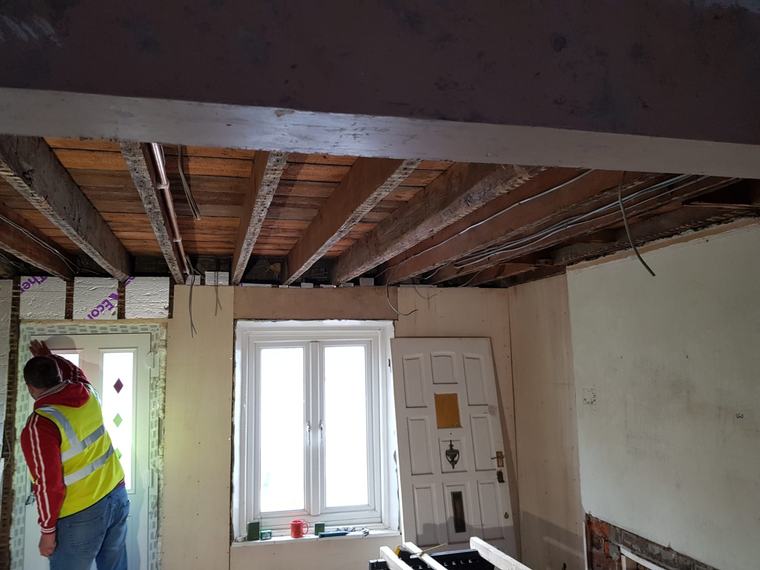 Interior refurbishment with exposed ceiling joists and wiring