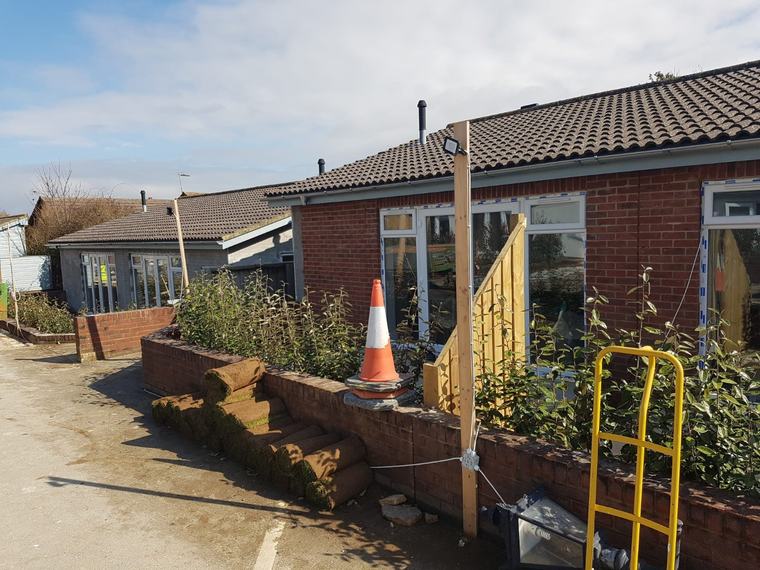 Exterior refurbishment work on brick building with windows