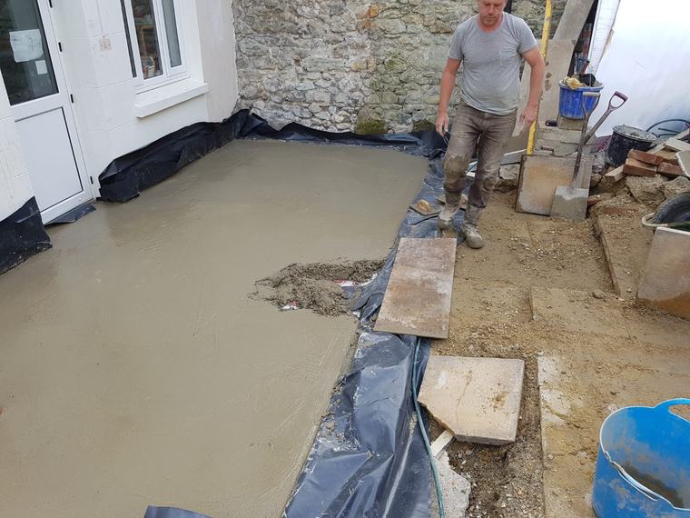 Fresh concrete slab being prepared outside a property