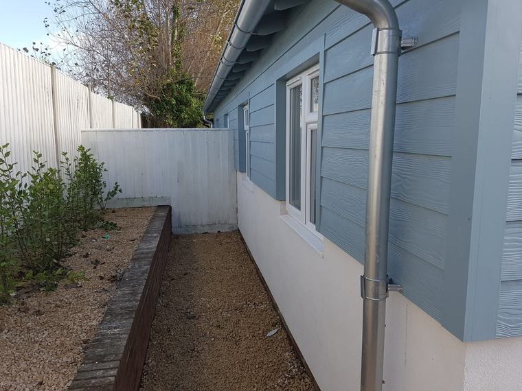 Finished blue cladding and guttering on side elevation