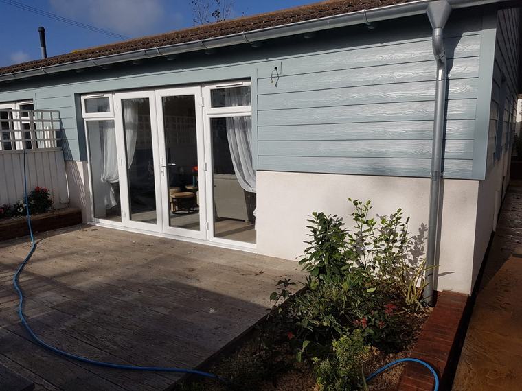Finished blue cladding exterior with white patio doors