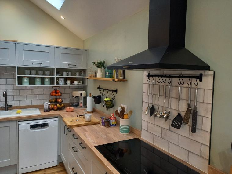 Kitchen cooker area with extractor, tiles and grey units